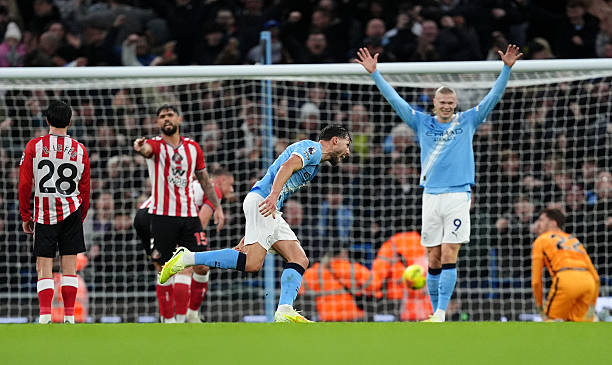 Manchester City's Ruben Dias (centre) celebrates with Bernardo Silva after scoring their side's first goal of the game during the Premier League match at the Etihad Stadium, Manchester. Picture date: Saturday December 6, 2025. (Photo by Martin Rickett/PA Images via Getty Images)