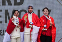 Mubarokah Dewi Laila of Indonesia, the gold medalist, celebrates on the podium during the medal ceremony with Karini Dominique Rachmawati of Indonesia, the silver medalist, and Phi Thanh Thao of Vietnam, the bronze medalist, at the women's 10m Air Rifle final at the 33rd Sea Games in SAT Shooting Range, Bangkok, Thailand, on December 13, 2025. (Photo by Anusak Laowilas/NurPhoto via Getty Images)