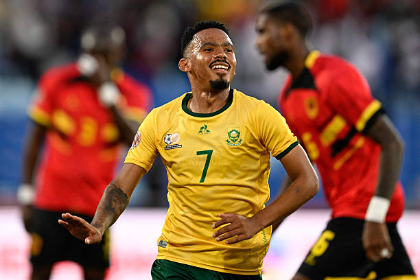 South Africa's midfielder #07 Oswin Appollis (C) celebrates scoring his team's first goal during the Africa Cup of Nations (CAN) Group B football match between South Africa and Angola at Marrakesh Stadium in Marrakesh, Morocco on December 22, 2025. (Photo by Khaled DESOUKI / AFP via Getty Images)