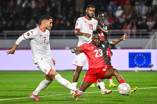 Tunisia's forward #07 Elias Achouri scores agoal in front of Uganda's defender #23 Aziz Kayondo during the Africa Cup of Nations (CAN) Group C football match between Tunisia and Uganda at Rabat Olympic Stadium in Rabat on December 23, 2025. (Photo by SEBASTIEN BOZON / AFP via Getty Images)