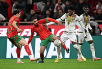 Morocco's defender #03 Noussair Mazraoui and Mali's forward #21 Gaoussou Diarra compete for the ball during the Africa Cup of Nations (CAN) Group A football match between Morocco and Mali at Prince Moulay Abdellah Stadium in Rabat on December 26, 2025. (Photo by Gabriel BOUYS / AFP via Getty Images)
