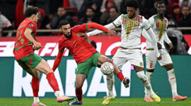 Morocco's defender #03 Noussair Mazraoui and Mali's forward #21 Gaoussou Diarra compete for the ball during the Africa Cup of Nations (CAN) Group A football match between Morocco and Mali at Prince Moulay Abdellah Stadium in Rabat on December 26, 2025. (Photo by Gabriel BOUYS / AFP via Getty Images)