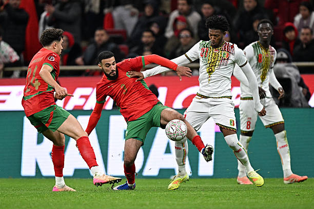 Morocco's defender #03 Noussair Mazraoui and Mali's forward #21 Gaoussou Diarra compete for the ball during the Africa Cup of Nations (CAN) Group A football match between Morocco and Mali at Prince Moulay Abdellah Stadium in Rabat on December 26, 2025. (Photo by Gabriel BOUYS / AFP via Getty Images)