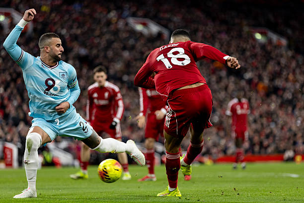 LIVERPOOL, ENGLAND - JANUARY 17: Cody Gakpo of Liverpool passes the ball as he is being challenged by Kyle Walker of Burnley during the Premier League match between Liverpool and Burnley at Anfield on January 17, 2026 in Liverpool, England. (Photo by Gaspafotos/MB Media/Getty Images)